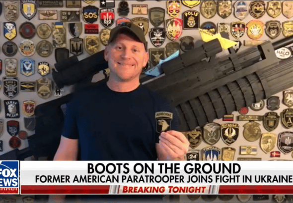 American neo-Nazi Paul Gray on Fox News in front of a wall featuring emblems of fascist militias like the Azov Battallion. Photo: Author