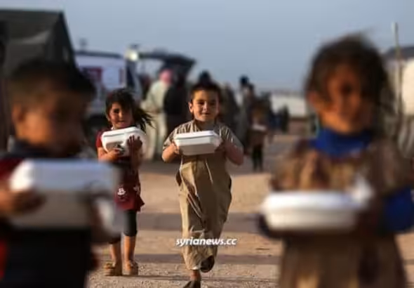 Syrian children in a refugee camp holding boxes of food delivered by humanitarian organizations. Syria is suffering an extreme food shortage as US-NATO forces continue to steal wheat from occupied north-eastern Syria. Photo: Syria News.