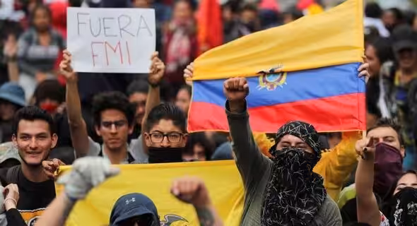 Protesters in Ecuador in 2019 holding a Fuera IMF [IMF get out] banner and the Ecuadorian flag, rallying against then President Lenin Moreno's submissive position towards the IMF. File photo.