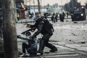 Police attack a man in protest in Bogotá, April 30, 2021. Photo: Luisa González / Reuters.