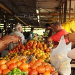 Woman buying vegetables in a popular market. File photo.