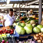 One person in a street market looking at vegetable. Photo: PxHere.