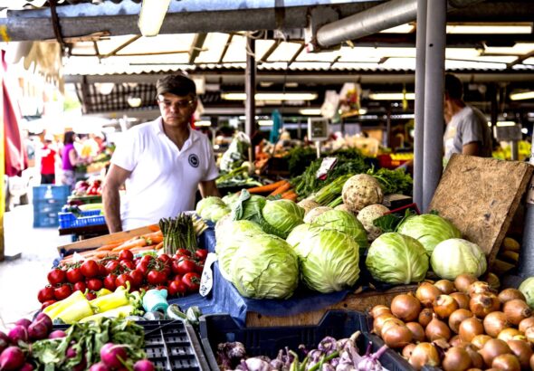 One person in a street market looking at vegetable. Photo: PxHere.