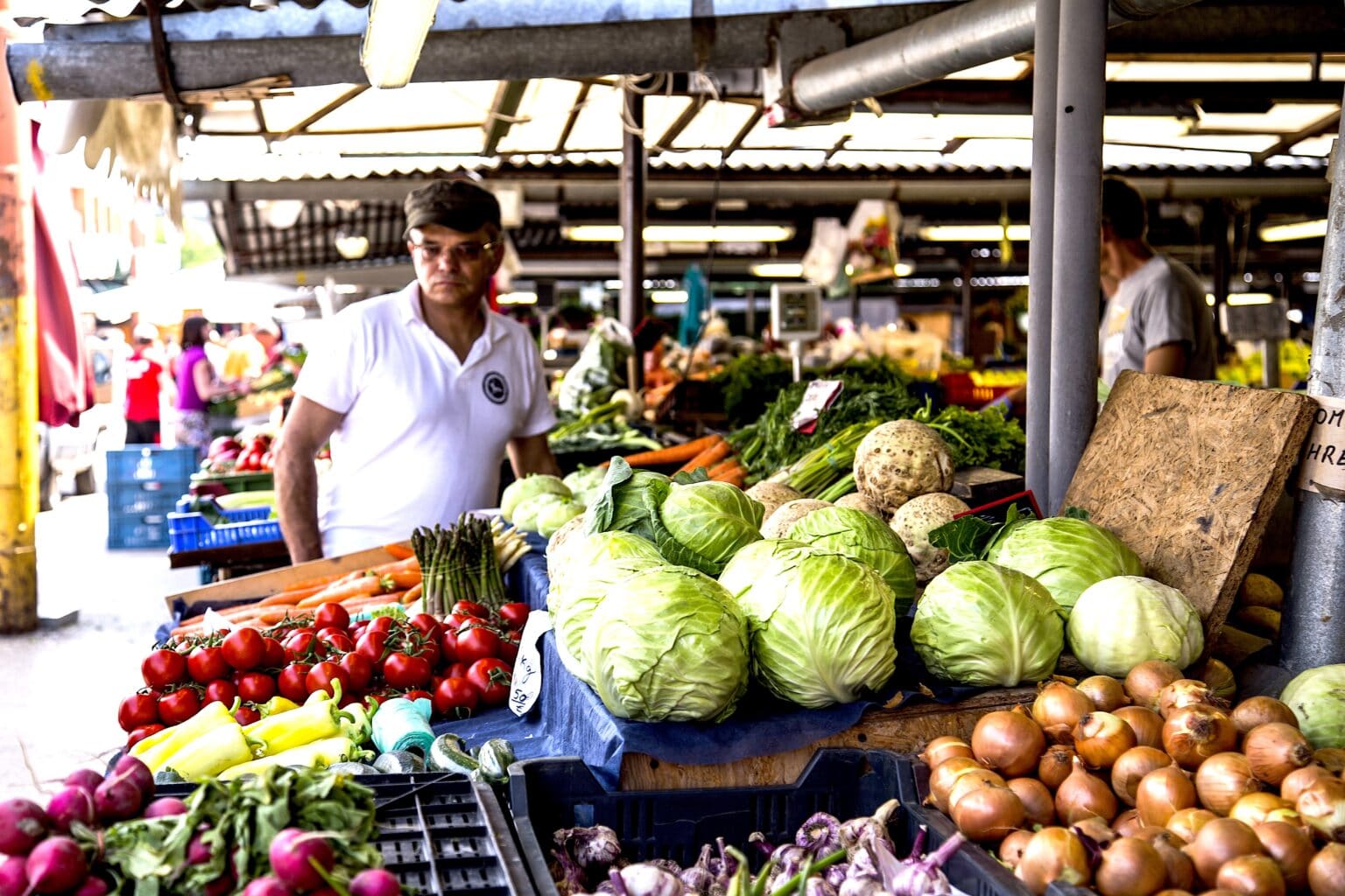 One person in a street market looking at vegetable. Photo: PxHere.