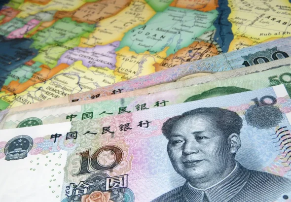 Photo composition showing Yuan bills over a map of Africa. Photo: Shutterstock.
