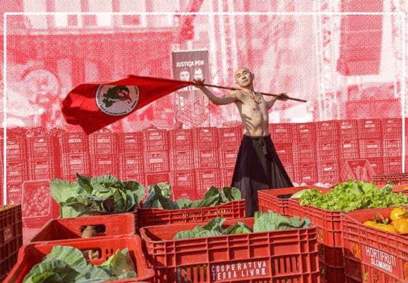 A militant of Brazil's Landless Workers' Movement (MST) flies the organizations flag at a cooperative market. Photo: Wellington Lenon/MST-PR.
