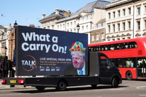 A mobile advertising board, featuring UK Prime Minister Boris Johnson dressed as a clown, drives near Downing Street in London, the United Kingdom. Photo: Phil Noble/Reuters.