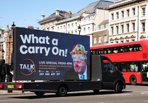 A mobile advertising board, featuring UK Prime Minister Boris Johnson dressed as a clown, drives near Downing Street in London, the United Kingdom. Photo: Phil Noble/Reuters.