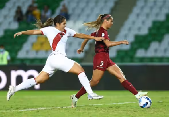 Venezuela's Deyna Castellanos runs with the ball while a Peruvian player chases her, seconds before scoring the first goal. Photo: Twitter/@CopaAmerica.