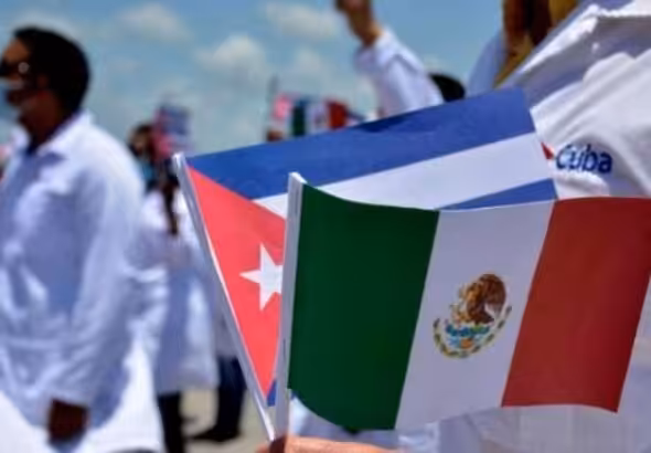 A Cuban doctor holding flags of Mexico and Cuba during a public ceremony. File photo.