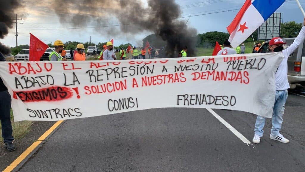 Strikers walking in the streets with a banner saying low cost of living. Photo: Suntracs.