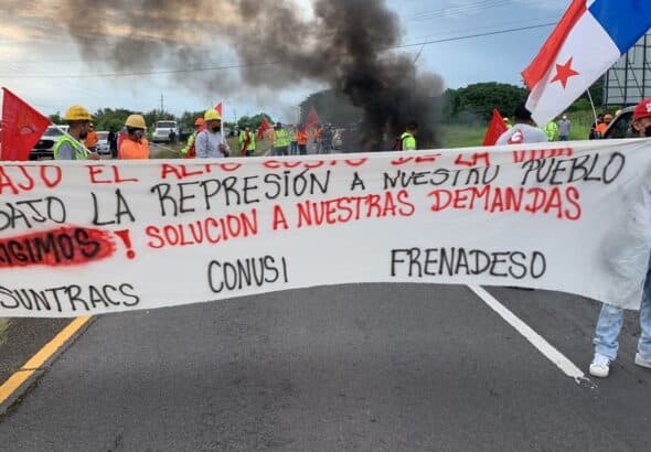 Strikers walking in the streets with a banner saying low cost of living. Photo: Suntracs.