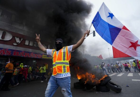 A protester raises the flag of Panama at a protest venue. Photo from social media.