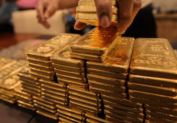 Gold ingots being piled on a table. Photo: Getty Images.