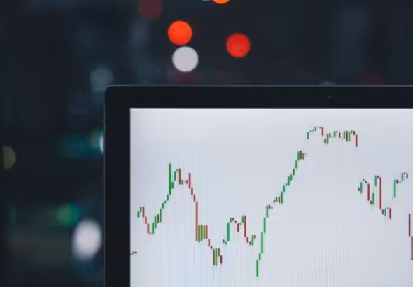 Screen showing a graph and city lights in the background. Photo: @m_____me