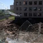 A large crater is visible in a school yard from overnight shelling as Russia’s attack on Ukraine continues in Kharkiv, Ukraine, on June 27. Photo: Leah Millis/Reuters.