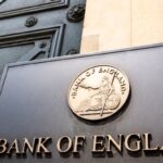 Bank of England headquarters's entrance in London with a view of its logo. Photo: iea.org.uk.