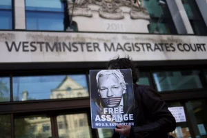 A supporter of Julian Assange displays a poster outside the Westminster Magistrates' Court in London, Britain on April 20, 2022. The UK Home Secretary on June 17, 2022, approved Assange's extradition to the U.S. Photo: Reuters/Tom Nicholson.