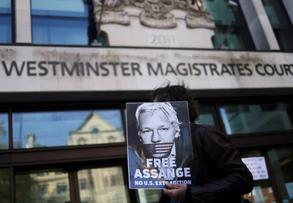 A supporter of Julian Assange displays a poster outside the Westminster Magistrates' Court in London, Britain on April 20, 2022. The UK Home Secretary on June 17, 2022, approved Assange's extradition to the U.S. Photo: Reuters/Tom Nicholson.