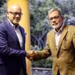 Gerardo Blyde (right) shakes hand of Jorge Rodríguez (left). Photo: Telesur.