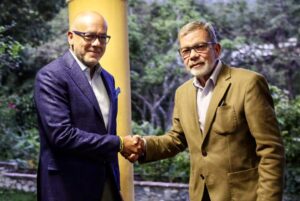 Gerardo Blyde (right) shakes hand of Jorge Rodríguez (left). Photo: Telesur.