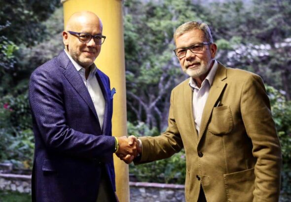 Gerardo Blyde (right) shakes hand of Jorge Rodríguez (left). Photo: Telesur.