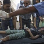 Palestinian medics transport an injured girl to the hospital following a reported Israeli strike in Rafah in the southern Gaza Strip, late on August 6, 2022.  Photo by AFP.