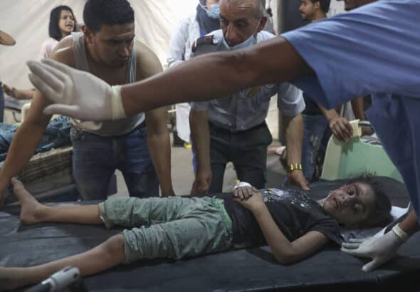 Palestinian medics transport an injured girl to the hospital following a reported Israeli strike in Rafah in the southern Gaza Strip, late on August 6, 2022.  Photo by AFP.