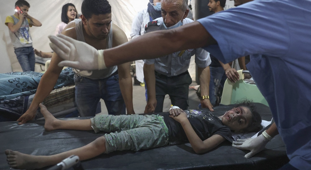 Palestinian medics transport an injured girl to the hospital following a reported Israeli strike in Rafah in the southern Gaza Strip, late on August 6, 2022.  Photo by AFP.