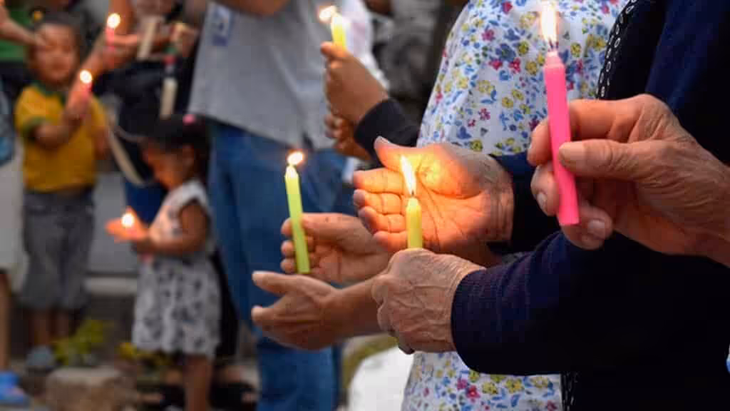 People holding candles in a public ceremony. Photo: Radio Nacional CO/Twitter