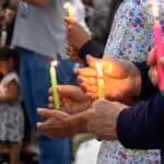 People holding candles in a public ceremony. Photo: Radio Nacional CO/Twitter