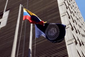 Venezuela's Central Bank (BCV) headquarters in Caracas next to a BCV and a Venezuelan flag. File photo.