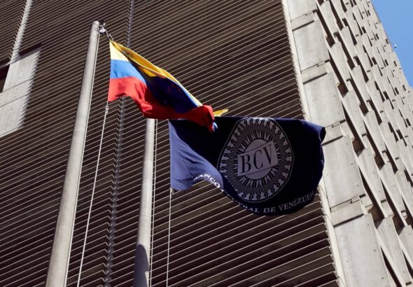 Venezuela's Central Bank (BCV) headquarters in Caracas next to a BCV and a Venezuelan flag. File photo.