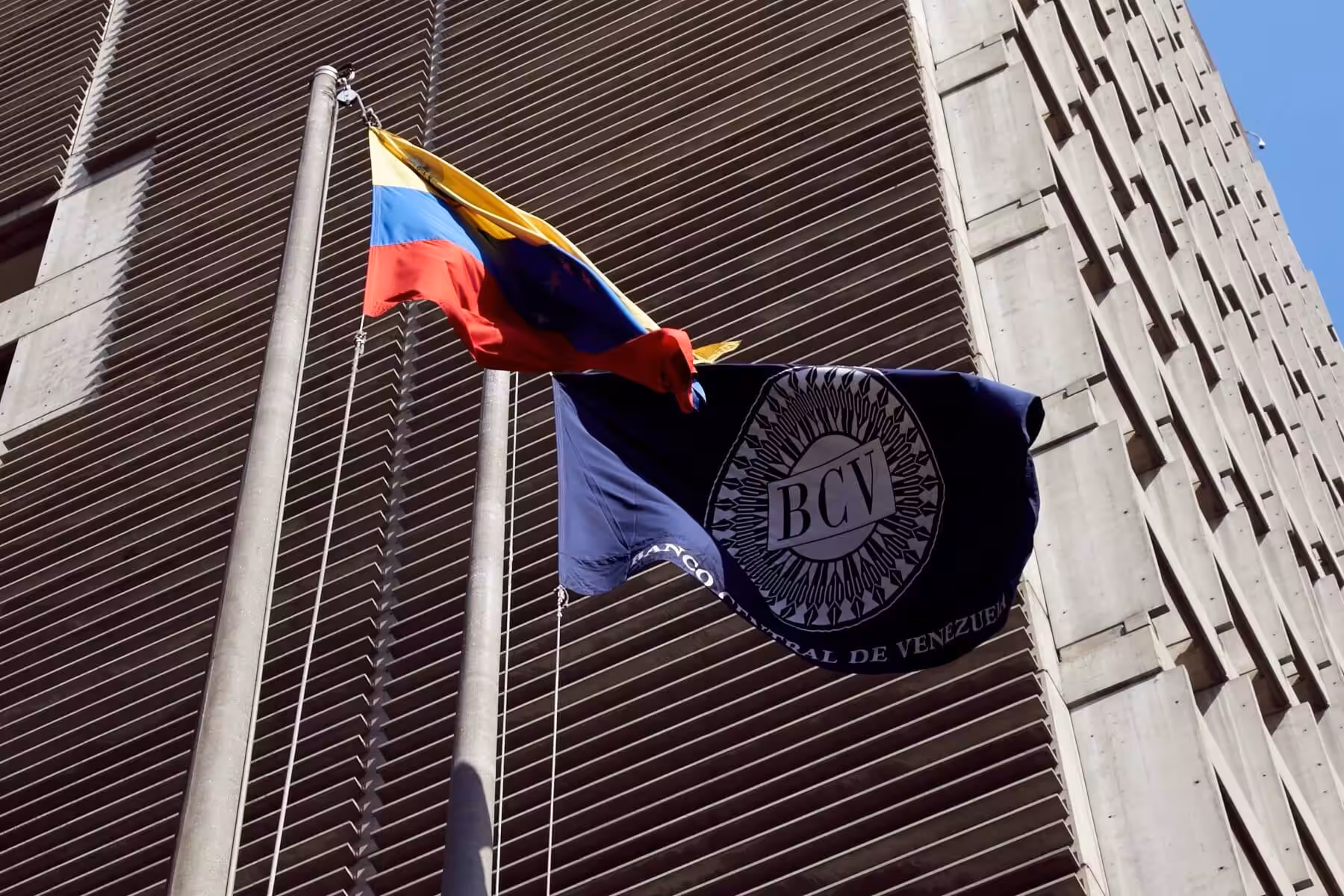 Venezuela's Central Bank (BCV) headquarters in Caracas next to BCV and Venezuelan flags. File photo.