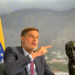 Félix Plasencia, the new Venezuelan ambassador to Colombia and former minister for foreign affairs, next to a sculpture of Simon Bolivar and the Venezuelan flag in an office showing the Warairarepano mountain of Caracas in the background. File photo.