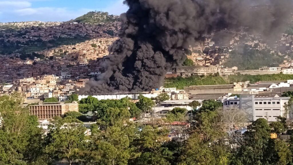 A big trail of black smoke coming out from the IVSS La Yaguara warehouse in Caracas, as seen from a safe distance. Photo: Twitter/@RCR750.