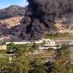 A big trail of black smoke coming out from the IVSS La Yaguara warehouse in Caracas, as seen from a safe distance. Photo: Twitter/@RCR750.