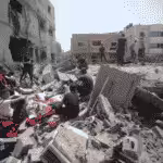 Palestinians among the rubble of a destroyed city block in Gaza. Photo: Mahmoud Ajjour/The Palestine Chronicle.