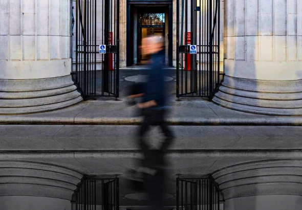 A passerby walking along the front of King's College London. Photo: MintPress News.