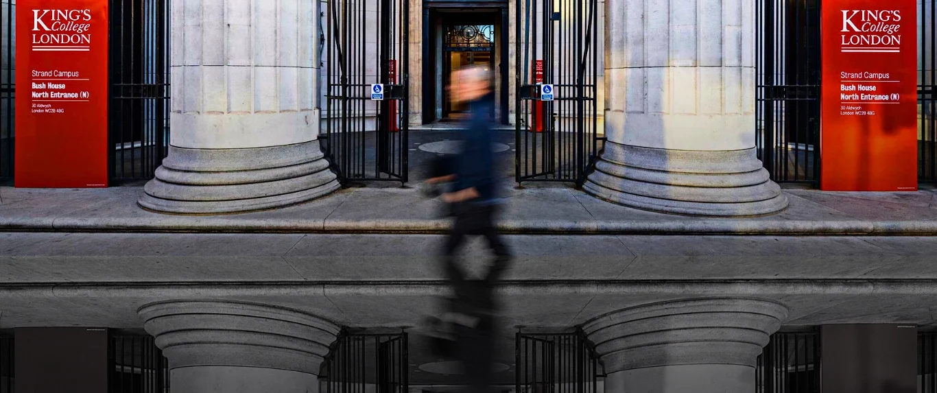 A passerby walking along the front of King's College London. Photo: MintPress News.