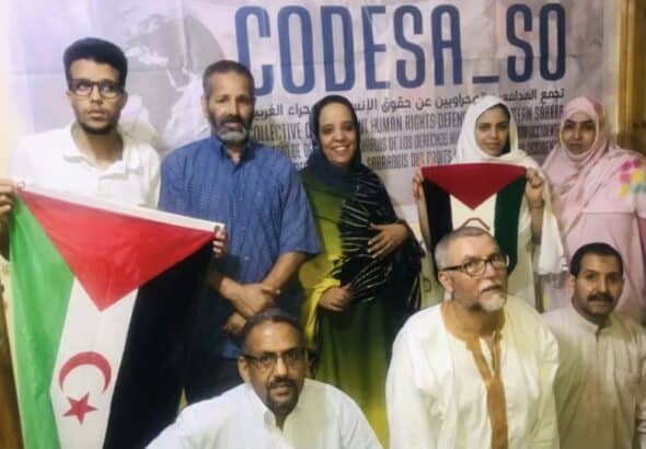 Members of Sahrawi human rights organization CODESA hold the flag of the Sahrawi Arab Democratic Republic as they present their first report on war crimes by Morocco in Western Sahara. Photo: CODESA.