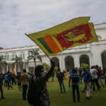 Protesters carry the Sri Lankan flag