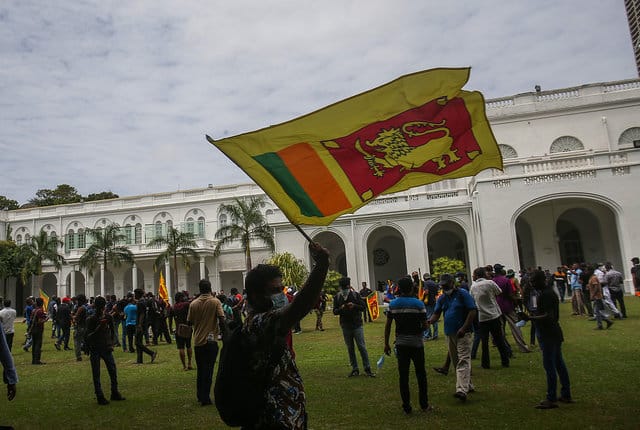 Protesters carry the Sri Lankan flag