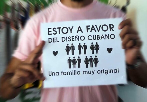 A person holds a sign that reads: "I am in favor of Cuban design" (figures of people appear in the sign where there are women-men, men-men, women-women, men-women-men and women-men- women) and ends with: A very original family. File photo.