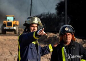 Two firefighters in Cuba on pointing at something. Photo: Granma/Ricardo López Hevia.