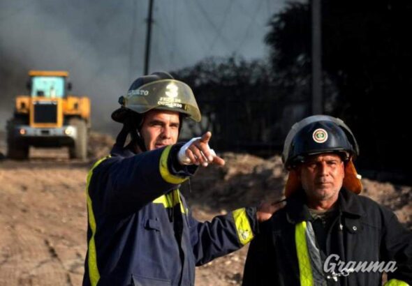 Two firefighters in Cuba on pointing at something. Photo: Granma/Ricardo López Hevia.