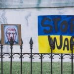 Wall painted with the face of the Russian president with blood in his eyes and next to it a propaganda that says stop war over a Ukrainian flag. Photo: Gayatri Malhotra