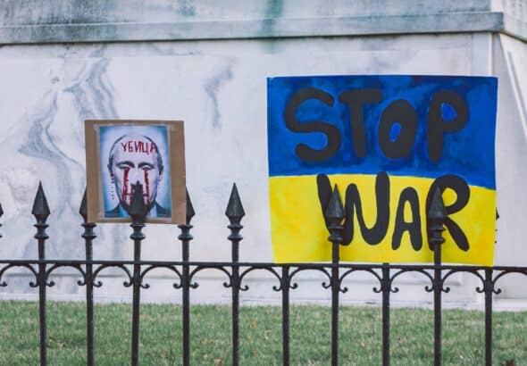Wall painted with the face of the Russian president with blood in his eyes and next to it a propaganda that says stop war over a Ukrainian flag. Photo: Gayatri Malhotra