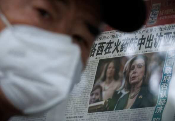A man stands in front of a glass cabinet displaying a Global Times newspaper that features a front-page article about U.S. House of Representatives Speaker Nancy Pelosi's Asia tour, in Beijing on Monday. The front page headline reads: "Pelosi visits Asia in the smell of gunpowder." Photo: Reuters.
