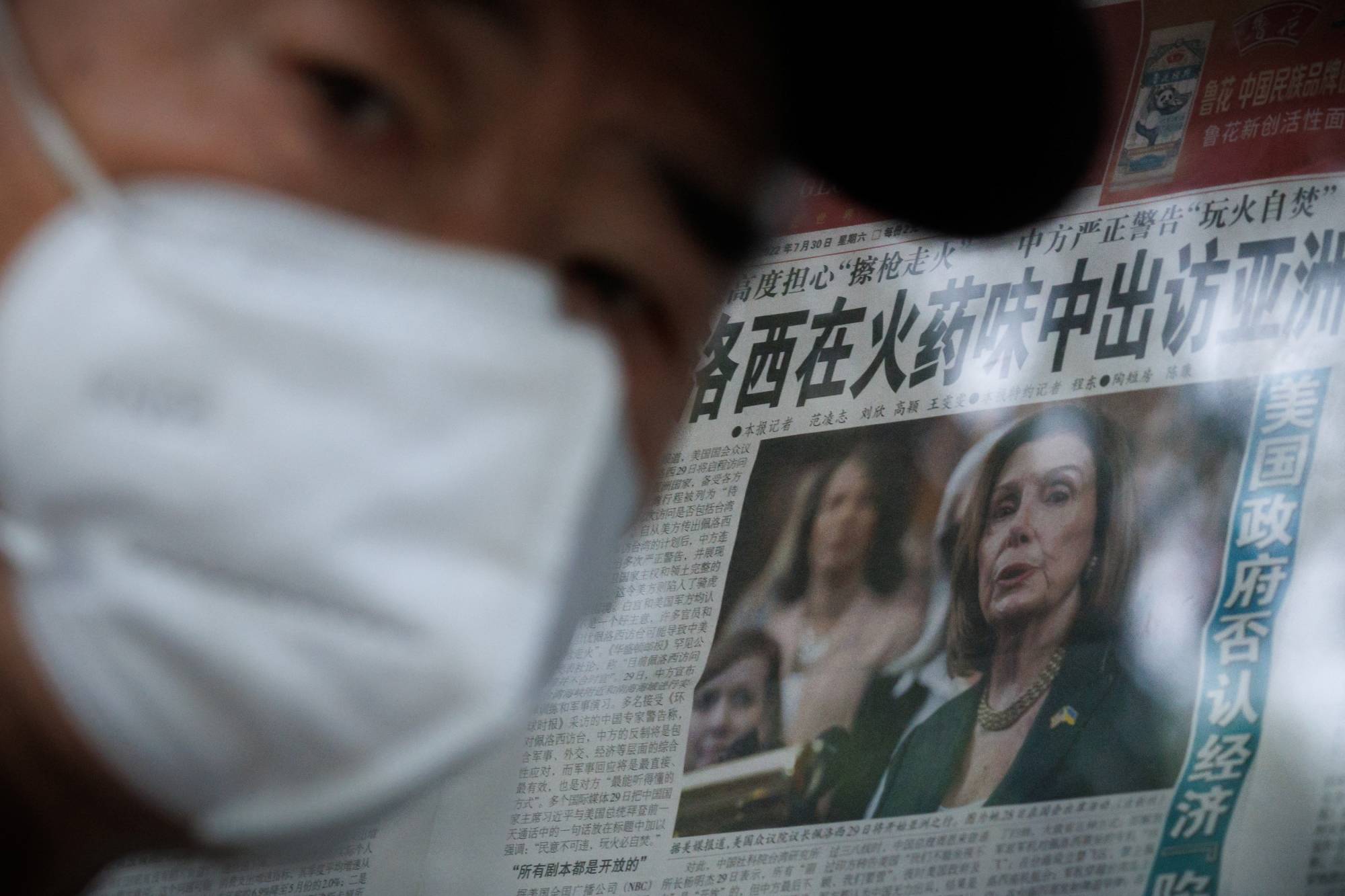 A man stands in front of a glass cabinet displaying a Global Times newspaper that features a front-page article about U.S. House of Representatives Speaker Nancy Pelosi's Asia tour, in Beijing on Monday. The front page headline reads: "Pelosi visits Asia in the smell of gunpowder." Photo: Reuters.